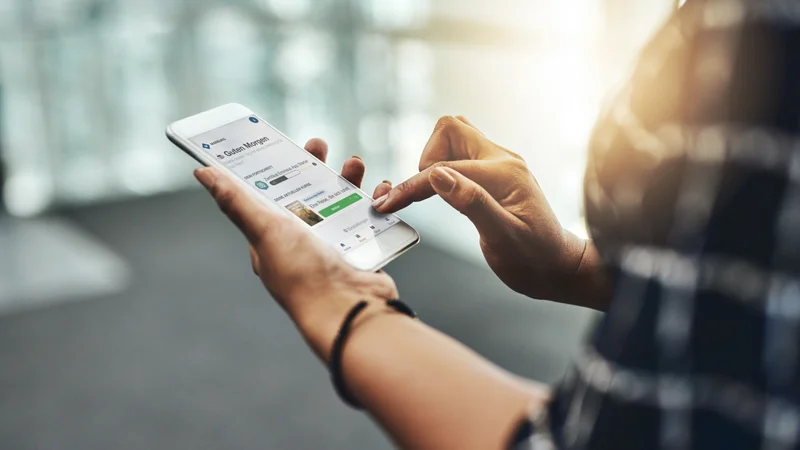 Smartphone mit App-Interface in Händen gehalten